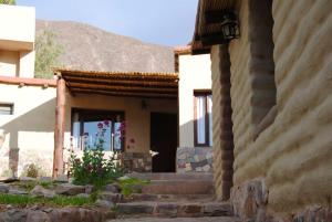 a house with stairs leading up to a door at ENTRECERROS, Tilcara in Tilcara