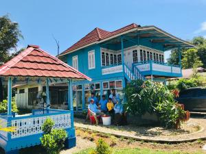 a group of people in front of a blue house at Petra Garden in Sungailiku