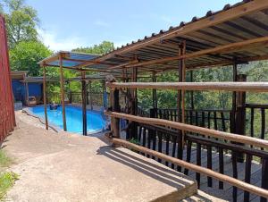 a swimming pool with a wooden pergola at Thula Du Estate - family houses in Mbabane