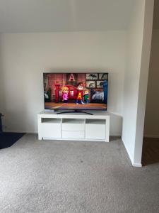 una TV a schermo piatto seduta sopra un centro di intrattenimento bianco di Remarkable stay 2 a Queenstown Airport
