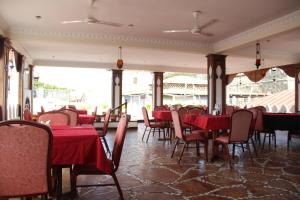 una sala da pranzo con tavoli, sedie e tovaglie rosse di Al-Minar Hotel a Zanzibar City