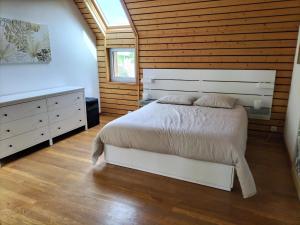 een slaapkamer met een wit bed en een houten muur bij Large House Near Beach for 12 in Trébeurden +27 foto's