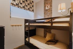 a room with two bunk beds in it with a lamp at L'Eveil - 65m2 - 6-8P - Centre Ville Cauterets in Cauterets +13 photos
