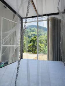 Un dormitorio con una cama con vistas a la montaña. en Ella Thenulya, en Ella