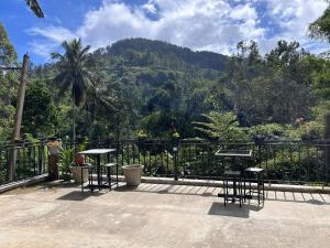 a patio with tables and chairs and a view of a mountain at Ella Thenulya in Ella