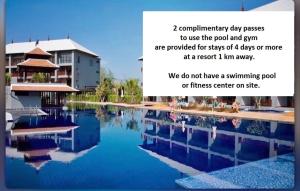 a sign next to a swimming pool with a building at Songbird Suites in Ban Khlong Haeng