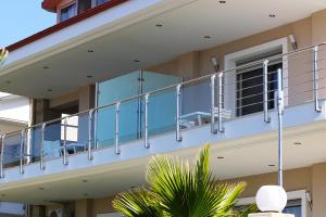 un balcón de una casa con barandilla azul en Toroni Luxury Villas, en Toroni