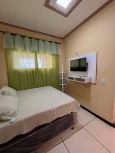 a bedroom with a bed and a flat screen tv at Flat Terra do Sol - Jijoca in Jijoca de Jericoacoara