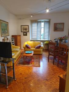 a living room with a yellow couch and a table at B&B del centro in Pinerolo