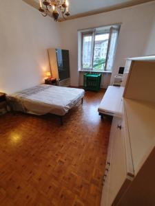 a bedroom with a bed and a wooden floor at B&B del centro in Pinerolo