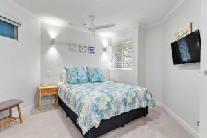 a bedroom with a bed and a tv on the wall at 6 Parkshores Sunshine Location Location Location 100m to beach access in Sunshine Beach