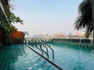 a swimming pool with turquoise tiles in a building at Hotel du Monde Art in Hanoi