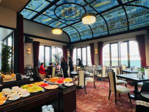 a dining room with a table filled with food at Hotel du Monde Art in Hanoi