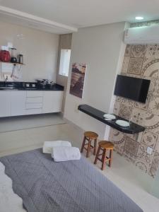 a kitchen with a table and two stools in a room at Jabuticaba Sabará - Frente ao Mar na Praia de Meaípe, Guarapari in Guarapari +16 photos