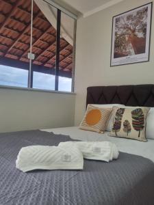 a bed with two white towels on top of it at Jabuticaba Sabará - Frente ao Mar na Praia de Meaípe, Guarapari in Guarapari