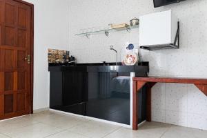 a kitchen with a black counter and a sink at Tucanos Buzios in Búzios