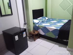 a bedroom with a bed and a small refrigerator at Lapa Casa Hostel in Rio de Janeiro