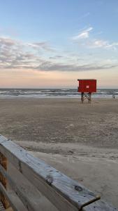 a red box sitting on a beach near the ocean at Apartamento 4 quadras do mar! in Xangri-lá