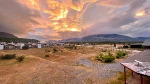 an image of a cloudy sky with houses in a field at El Mosco in Villa O'Higgins