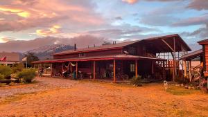a large building with a mountain in the background at El Mosco in Villa O'Higgins
