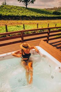 a person in a hot tub in a field at Capanna del Vale - Refúgio & Degustação no Vale dos Vinhedos in Bento Gonçalves