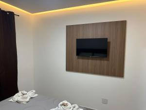 a room with a tv on a wall with towels at Pousada Vó Dena in Penha