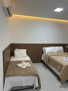 two beds sitting next to each other in a room at Pousada Vó Dena in Penha