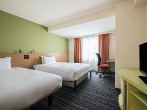 a hotel room with two beds and a television at the b ikebukuro in Tokyo