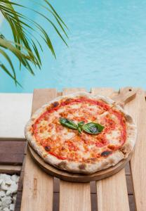 a pizza sitting on top of a wooden table at Baliterraneo Boutique Resort in Seminyak
