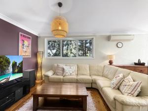 a living room with a couch and a tv at Riverside 3-Bed Townhouse with Spacious Deck & BBQ in Mossy Point