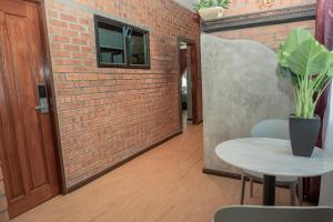 a room with a brick wall and a table with a potted plant at Bricks Guesthouse in Tanah Rata