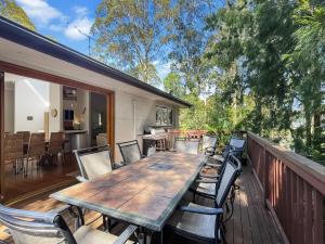 a wooden table and chairs on a deck at Riverside 3-Bed Townhouse with Spacious Deck & BBQ in Mossy Point