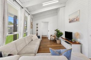 a living room with a couch and a tv at Lonsdale By The Sea in Point Lonsdale