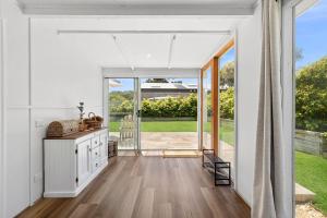 an open living room with white walls and sliding glass doors at Lonsdale By The Sea in Point Lonsdale