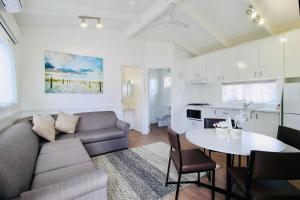 a living room with a couch and a table at Kanasta Caravan Park in Rye