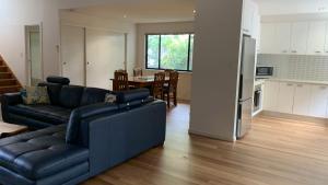 a living room with a couch and a kitchen at Hook Wine Sinker in Brunswick Heads