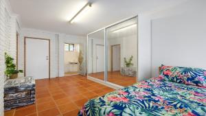 a bedroom with a bed and a large mirror at Seahorse On Fawcett in Brunswick Heads