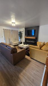 a living room with two couches and a flat screen tv at Luxury 4 Bedroom Modern Escape in Detroit