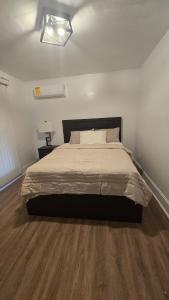 a bedroom with a large bed with a wooden floor at Luxury 4 Bedroom Modern Escape in Detroit