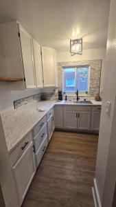 a kitchen with white cabinets and a sink and a window at Luxury 4 Bedroom Modern Escape in Detroit +7 photos