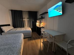 a hotel room with two beds and a flat screen tv at 4 person room 3min from South Wimbeldon tube station Room2 in London