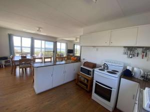a kitchen with white appliances and a dining room at 14 Brady Street in Mallacoota