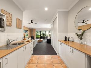 una cocina con armarios blancos y un espejo grande en Aroha, en Margaret River Town 11 fotos más