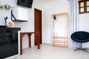 a living room with a black chair and a window at Tucanos Buzios in Búzios