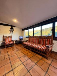 sala de estar con sofás, TV y ventanas en Finca El Cielo, en Huiluco