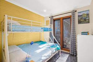 Camera con letto a castello, 2 letti a castello e finestra. di Ronnies Cottage a Mylestom