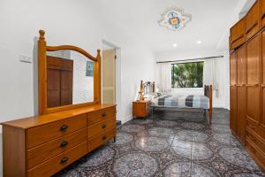 una camera da letto con cassettiera e un letto con finestra di Ronnies Cottage a Mylestom Altre 3 foto