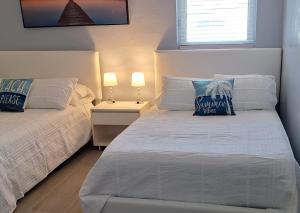 a white bedroom with two beds and two lamps at Family Getaway 3-bedroom Private Duplex House parking WiFi BBQ GRILL pet-friendly in Cutler Ridge