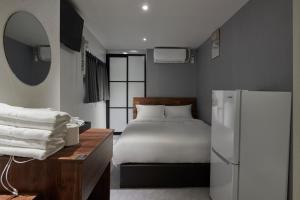 ソウルにあるEight Rest Hostel Jong-roのベッドルーム(ベッド1台、冷蔵庫付)