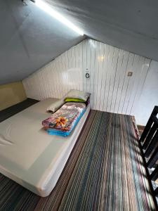 Cama pequeña en habitación pequeña con escalera en Homestay Ulya 1, en Banjarnegara